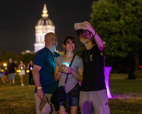 Student taking picture with family.